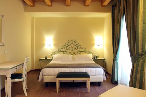 科莫焉提博古酒店的一间卧室配有一张床、一张桌子和一张四柱床。