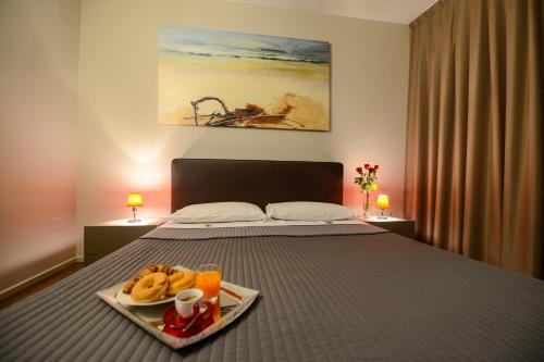马泰拉马泰拉国立公寓式酒店的一间卧室配有一张床,上面放着一个食物托盘