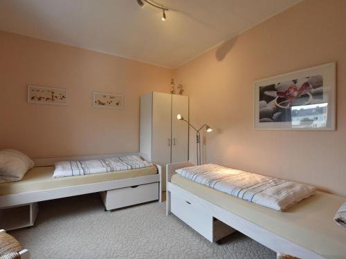维斯马Spacious Holiday Home in Wismar Germany with Parasol的一间卧室配有两张床和一台冰箱