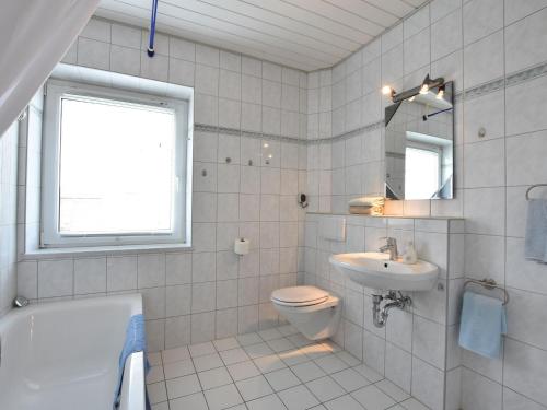 维斯马Spacious Holiday Home in Wismar Germany with Parasol的浴室配有卫生间、盥洗盆和浴缸。