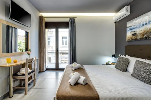 干尼亚City Breeze Apartment的一间卧室配有一张床、一张书桌和一个窗户。