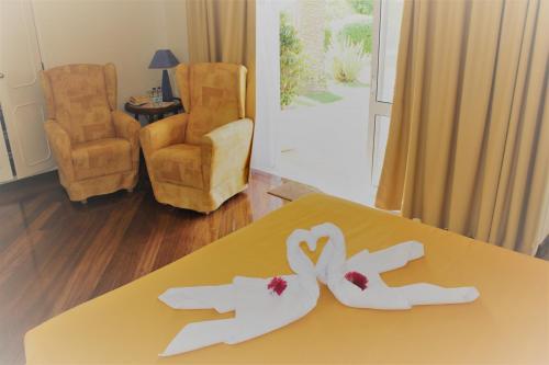 卡武埃鲁橄榄农场酒店的一张桌子上放着两只白手和鲜花