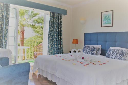 卡武埃鲁橄榄农场酒店的一间卧室配有一张带白色毯子的床和窗户。
