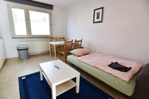 科隆科隆格雷姆贝格霍芬公寓的小房间设有一张床和一张桌子