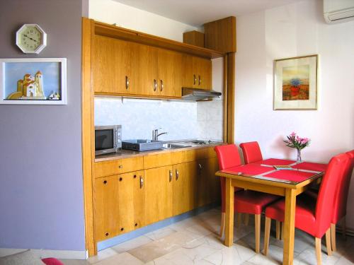 克尔克Apartments Oribella的一间带桌子和红色椅子的小厨房
