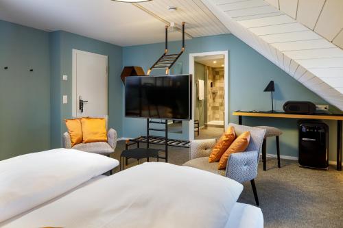 卢塞恩Hotel Münzgasse - Self Check-in的客厅配有电视、沙发和椅子