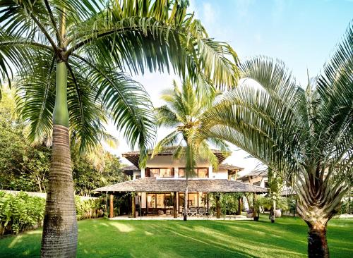 圣安德烈Campo Bahia Hotel Villas Spa的两棵棕榈树在房子前面