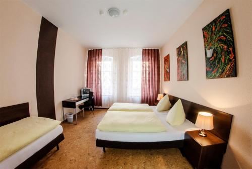 柏林维多利亚膳食公寓酒店的酒店客房配有两张床和一张书桌