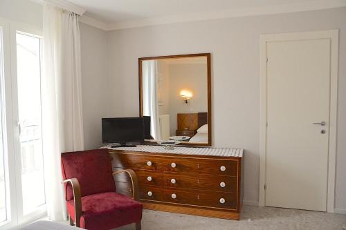 阿尔塔穆拉Vacanze Murgiane的一间卧室配有带镜子和红色椅子的梳妆台