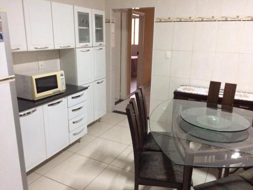 坎皮纳斯Casa Familiar em Campinas com 2 Quartos, 1 banheiro, 1 vaga para carro的厨房配有玻璃桌和微波炉