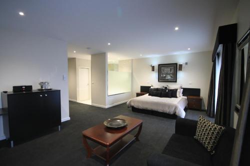 WallanHogans Motel的大型酒店客房设有一张床铺和一张桌子。