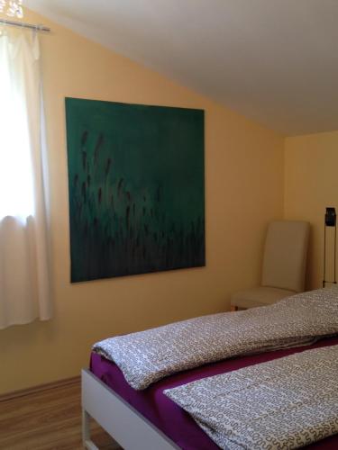 上韦瑟尔Künstlerhäuschen的卧室配有一张床,墙上挂有绘画作品