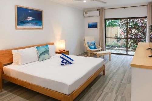 道格拉斯港Birch Resort Port Douglas的一间卧室设有一张床和一个大窗户