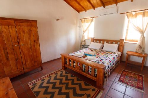 艾登Ionia Guest House的一间卧室配有木床和木柜