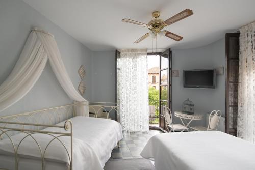 格拉纳达Pension Venecia Gomerez的一间卧室配有两张床和吊扇
