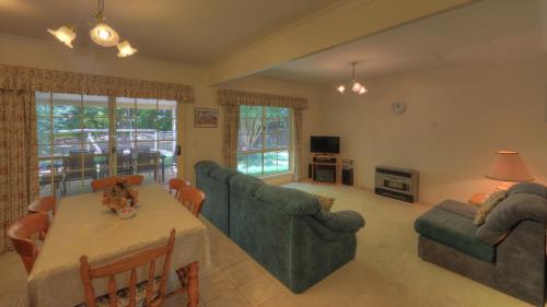 布赖特卢米内克斯小木屋别墅的客厅配有桌子和2张沙发