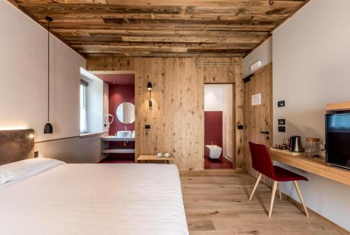 莱德罗Good Life Hotel Garden的卧室配有白色的床和红色椅子