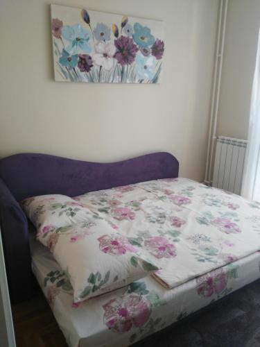 贝尔格莱德Vlado Apartment的床上有鲜花铺盖的毯子