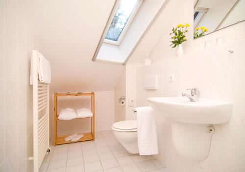 普雷罗Hotel Haus Linden的浴室配有盥洗池和天窗。