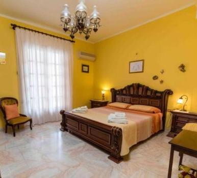 卡斯特布奥诺Casa Mare e Monti Castelbuono的一间卧室配有一张大床和一个吊灯。