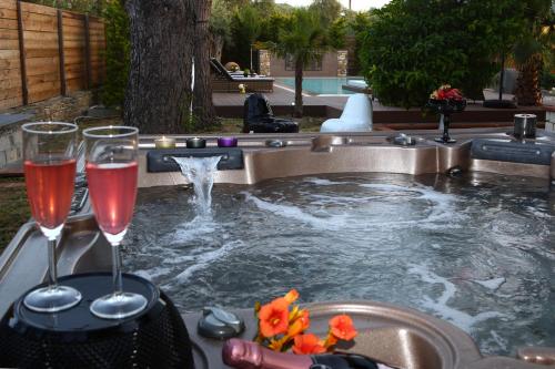 普里诺斯比布鲁斯豪华别墅的一座游泳池,里面装有两杯葡萄酒和一个喷泉