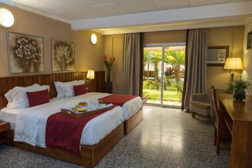 科托努杜拉克酒店的酒店客房设有一张大床和一张书桌。