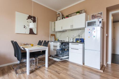 布拉格Eliška的厨房配有桌子和白色冰箱。