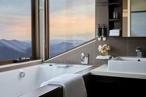 布勒山Breathtaker Hotel and Spa的带浴缸、水槽和窗户的浴室