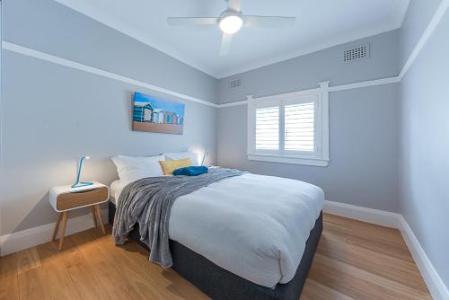 悉尼海滩度假公寓的一间卧室设有一张大床和一个窗户。