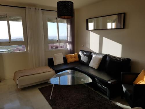 米哈斯科斯塔Residential ALAZAN的客厅配有黑色沙发和玻璃桌