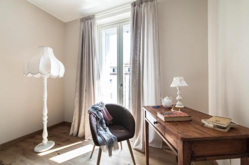 利沃诺Agave in Città的客房配有书桌、椅子和灯具