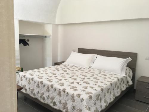 洛科罗通多Lamia Bianca的卧室配有带白色枕头的大床