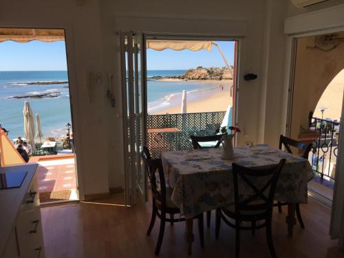 圣玛丽亚港Apartamento Pueblo Marinero Puerto Sherry的一间设有桌子并享有海滩美景的用餐室
