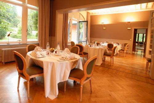 亨法尔马丁曼诺尔酒店的一间设有白色桌椅的用餐室