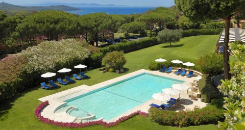 蓬塔阿拉加利亚宫酒店 - 餐厅&酒店的享有带椅子和遮阳伞的游泳池的上方景色