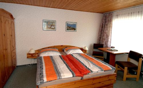 韦耶达Wiedaer Hütte的一间卧室配有一张床、一张书桌和一个窗户。