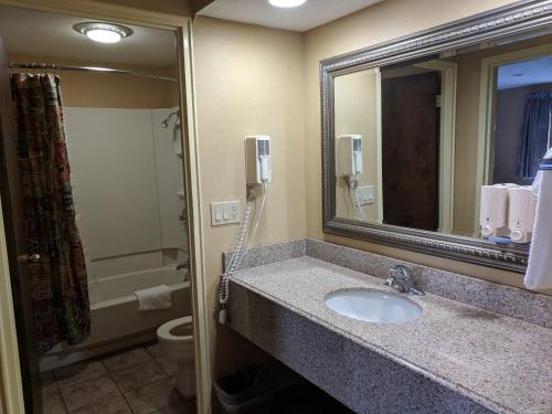 桑达斯基南岸酒店的一间带水槽和卫生间的浴室以及一部电话