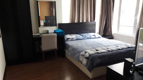 马六甲STUDIO ROOM at BAYOULAGOON RESORT, MELAKA的一间卧室配有一张床和一张桌子及椅子