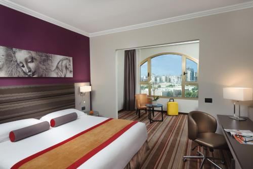 贝尔谢巴内盖夫莱昂纳多酒店的酒店客房设有一张床和一个大窗户