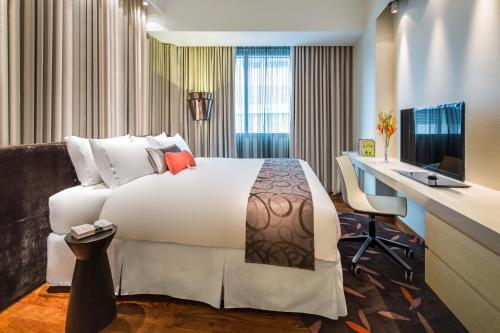 新加坡Park Avenue Rochester的酒店客房配有一张床、一张书桌和一台电脑
