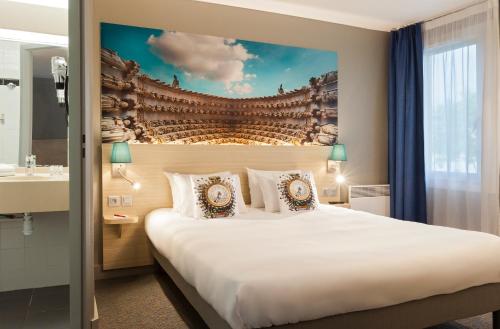 隆戈The Originals City, Tabl'Hôtel, Amiens的酒店客房设有一张大床和一个水槽
