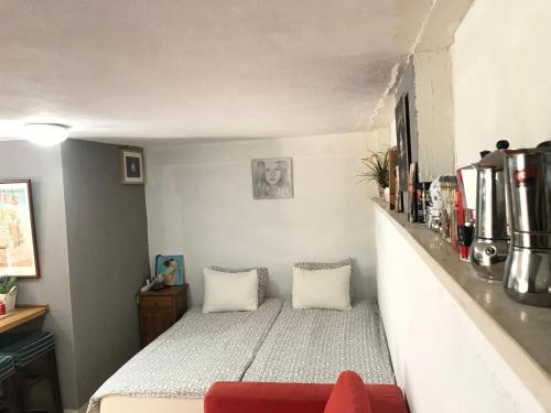 凯撒利亚Apartment Caesarea 38的一间小卧室,配有一张床和一张红色的沙发
