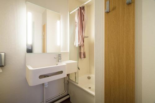特赫格欧B&B HOTEL Saint-Brieuc的浴室配有盥洗盆、镜子和浴缸