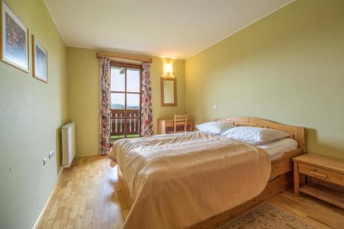 Ribnica na PohorjuApartmajsko naselje Ribniško Pohorje的一间卧室设有一张大床和一个窗户。