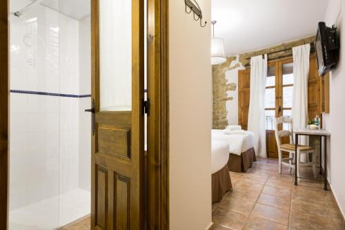 安卡斯提洛Posada de Uncastillo的带淋浴的浴室和卧室