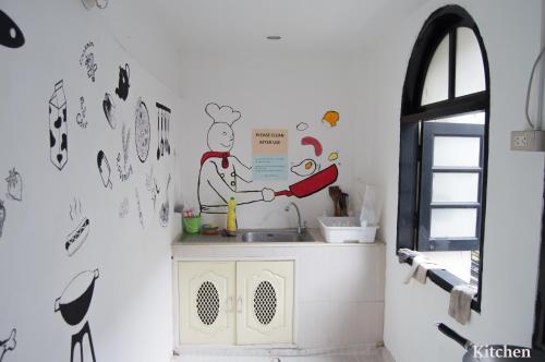 曼谷伊莎白旅舍的厨房配有水槽,墙上绘有厨师画