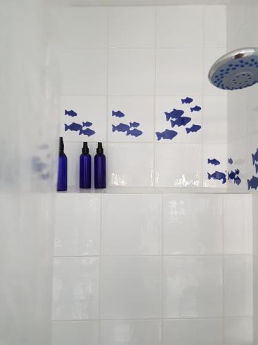 苏佩塔尔Apartment Tanja的浴室设有白色瓷砖墙壁,配有蓝色瓶子
