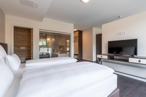 韦茨拉尔Trip Inn Conference Hotel & Suites的一间卧室配有两张床和一台平面电视