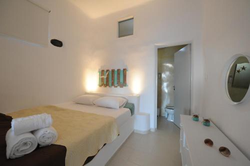 费拉马尼雅思费拉公寓的一间白色卧室,配有一张床和浴缸
