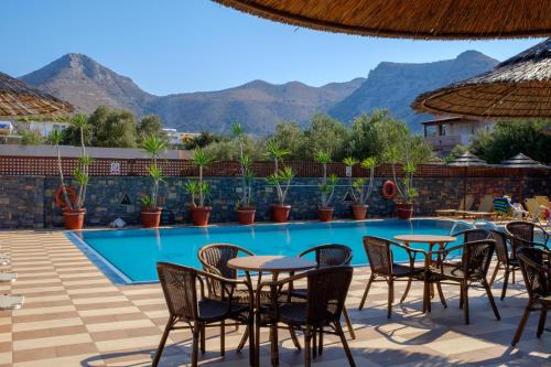 伊罗达克拉里一室公寓及波托贝洛公寓的酒店设有一个游泳池和桌椅